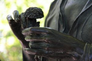 bronze art of person holding flower