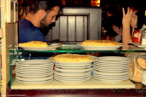 lots of plates on the bar,, 3 with tortillas on top
