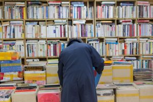 busy interior bookstore with man bending over to check book