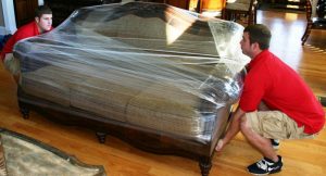 moving company transports couch in plastic wrapping