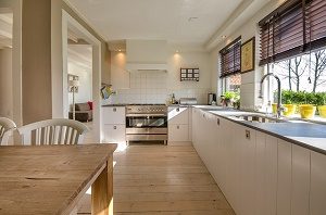 white kitchen with windows and wooden table