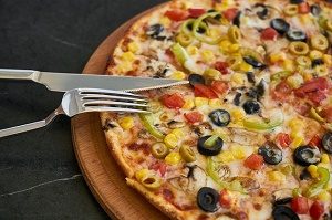 pizza with olives, fork and knife