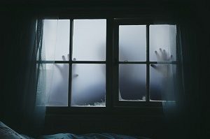 halloween hands against outside spooky window