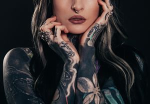 lady with nose piercing and arms full of tattoos