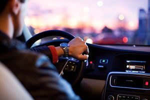 men's hand holds wheel of car