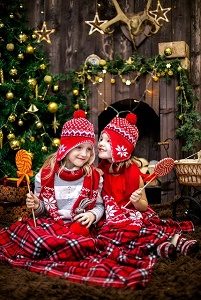 two kids under christmas tree