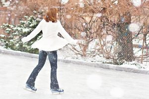 lady in white jacket ice skating outside