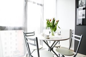 white table with white chairs and tulips