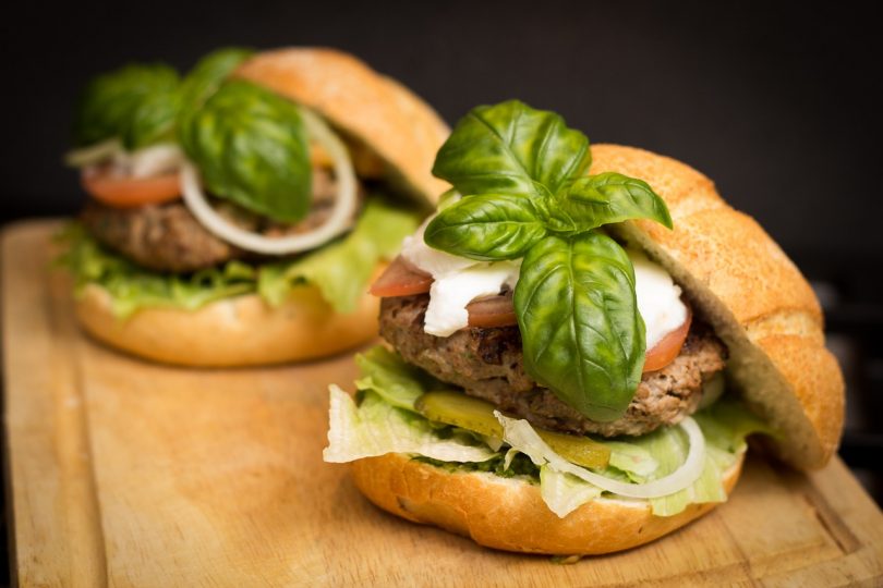 two hamburgers with basil on top