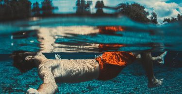 man in red trunks in pool