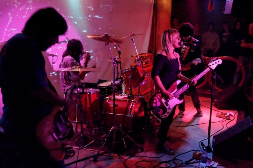 band with female singer in purple light