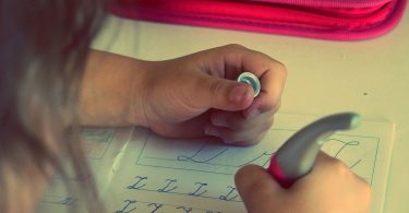 child learns to write letter Z