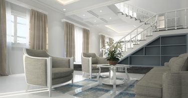 living room with light coloured furniture and white stairs