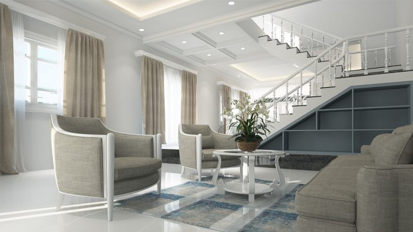 living room with light coloured furniture and white stairs