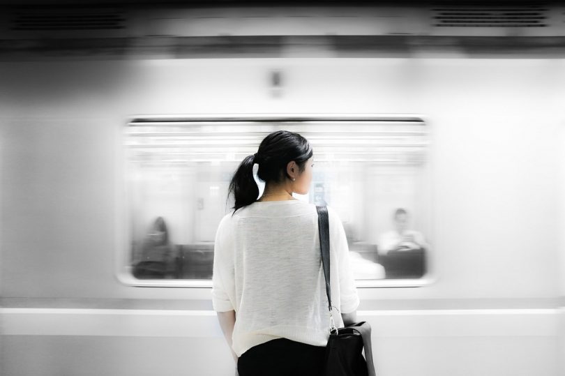 back of asian woman in train station