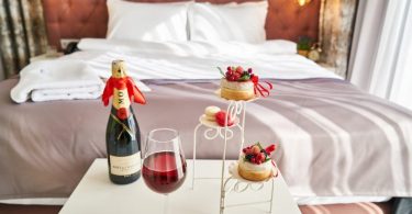 romantic hotel room with champagne and little cakes