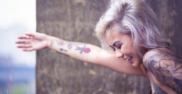 happy lady with tattoo on lower arm