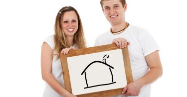 young couple holding drawing of a house