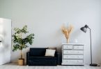 Habitación con sofá, cómoda, lámpara y armario
