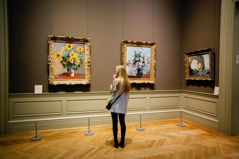 femme regardant des tableaux dans un musée