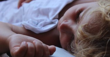 enfant qui dort dans un drap blanc
