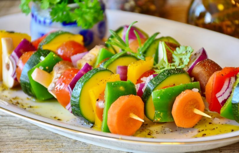 trois brochettes de legumes dans une assiette